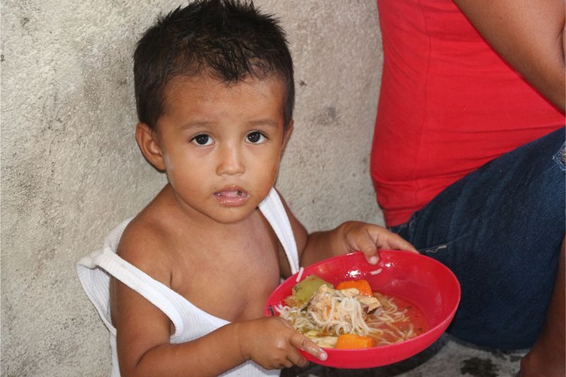 A mother with children at a meal distribution site